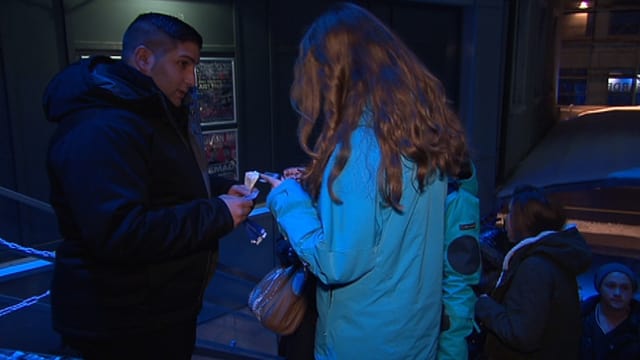 Türsteher kontrolliert Ausweis einer jungen Frau. Türsteher kontrolliert Ausweis einer jungen Frau.