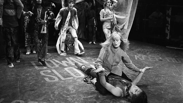 Eine Theaterbühne: Eine Frau sitzt auf einem Mann. Eine Theaterbühne: Eine Frau sitzt auf einem Mann.