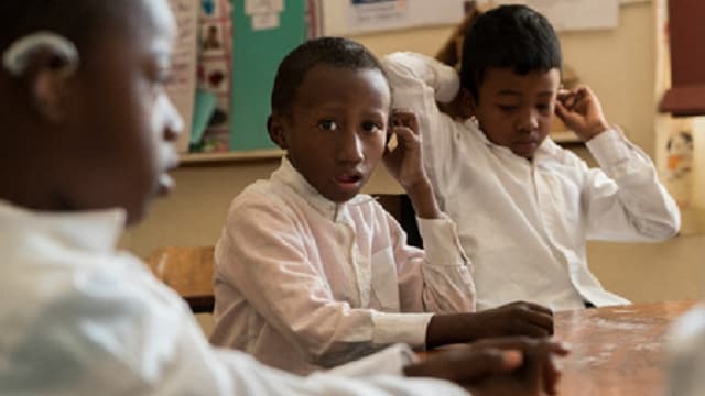 Drei hör- oder sehbehinderte Kinder in der Schule. Drei hör- oder sehbehinderte Kinder in der Schule.