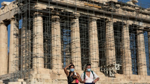 Zwei Frauen mit Maske vor der Akropolis. Zwei Frauen mit Maske vor der Akropolis.
