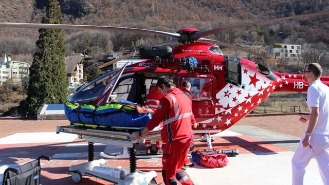 Heli, Patient auf einer Bahre und Pflegefachleute. Heli, Patient auf einer Bahre und Pflegefachleute.