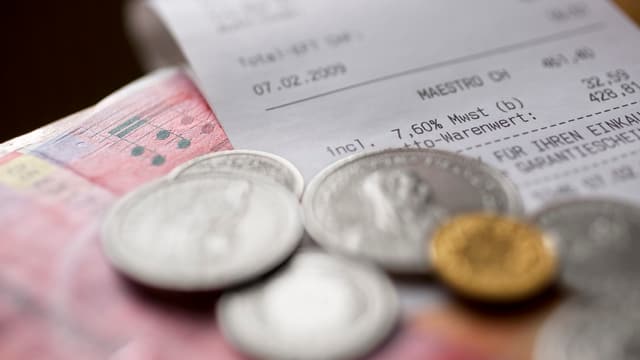 Ein Kassenzettel und Geldmünzen. Ein Kassenzettel und Geldmünzen.