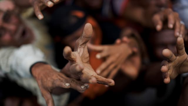 Flüchtlinge greifen nach Nahrungsmitteln, die verteilt werden. Flüchtlinge greifen nach Nahrungsmitteln, die verteilt werden.