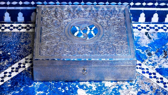 Eine silberne, verzierte Truhe mit dem Wu-Tang-Logo darauf. Eine silberne, verzierte Truhe mit dem Wu-Tang-Logo darauf.