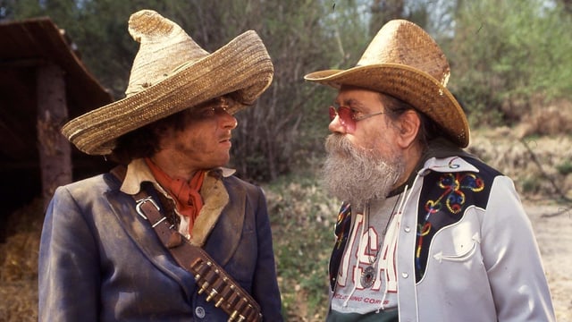 Helge Schneider als Doc Snyder in seinem ersten Kinofilm. Neben ihm ein Nebendarsteller, der Gott spielt. Helge Schneider als Doc Snyder in seinem ersten Kinofilm. Neben ihm ein Nebendarsteller, der Gott spielt.