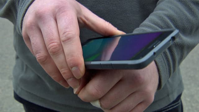 Hand hält Handy auf andere Hand. Hand hält Handy auf andere Hand.