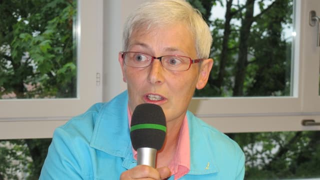 Claudia Künzi Während der Diskussion mit Mikrofon. Claudia Künzi Während der Diskussion mit Mikrofon.