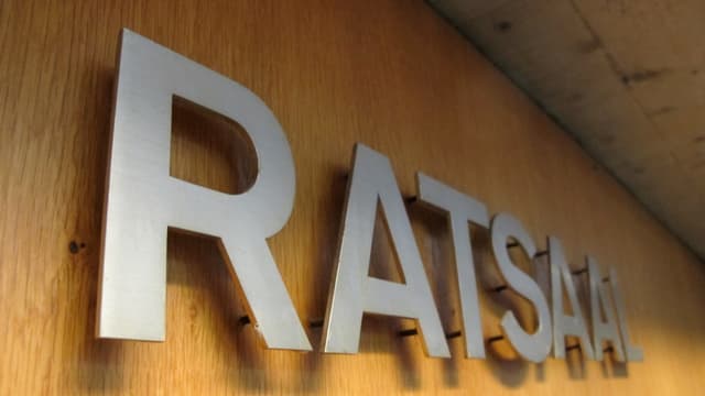 Vor dem Eingang zum Saal stehen "Ratssaal" Vor dem Eingang zum Saal stehen "Ratssaal"