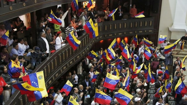 Mitglieder der Verfassungsgebenden Versammlung schwenken venezolanische Flaggen während einer Sitzung. Mitglieder der Verfassungsgebenden Versammlung schwenken venezolanische Flaggen während einer Sitzung.