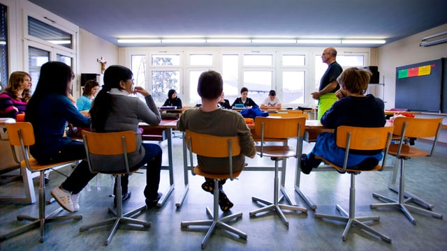 Schüler in einem Klassenzimmer mit einem Lehrer Schüler in einem Klassenzimmer mit einem Lehrer