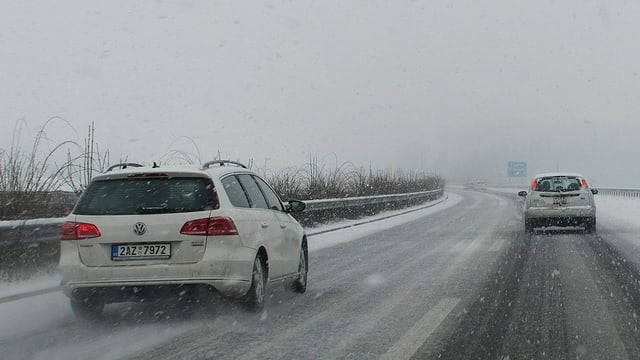Zwei weisse Autos fahren auf der vereisten Autobahn Zwei weisse Autos fahren auf der vereisten Autobahn