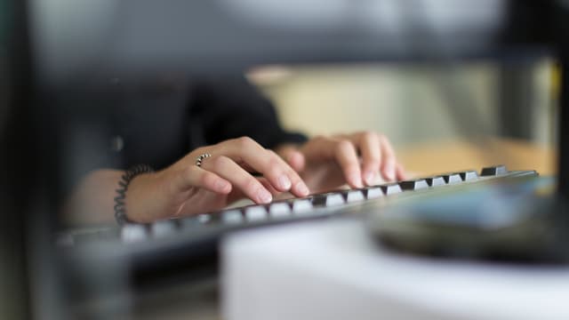 Frauenhände an einer Tastatur. Frauenhände an einer Tastatur.
