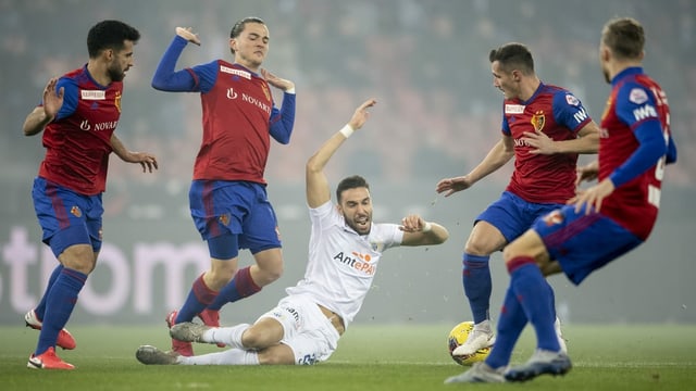Vier Basler Spieler um einen Zürcher Spieler herum, letzterer fällt zu Boden. Vier Basler Spieler um einen Zürcher Spieler herum, letzterer fällt zu Boden.
