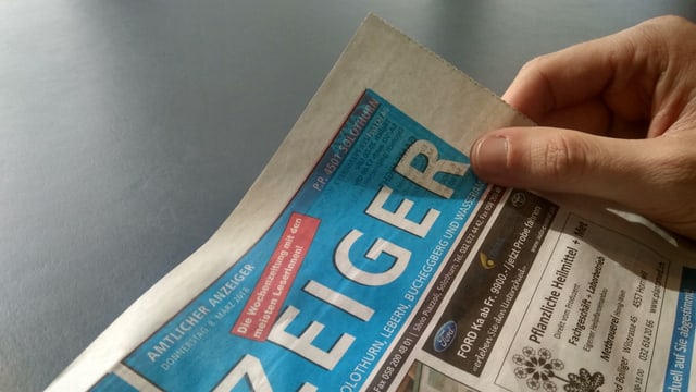 Eine Person blättert im Anzeiger der Stadt Solothurn Eine Person blättert im Anzeiger der Stadt Solothurn
