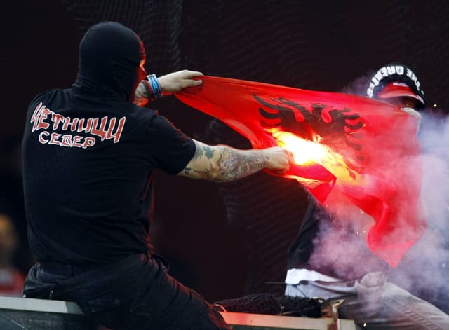 Ein serbischer Hooligan verbrennt eine kosovarische Flagge Ein serbischer Hooligan verbrennt eine kosovarische Flagge