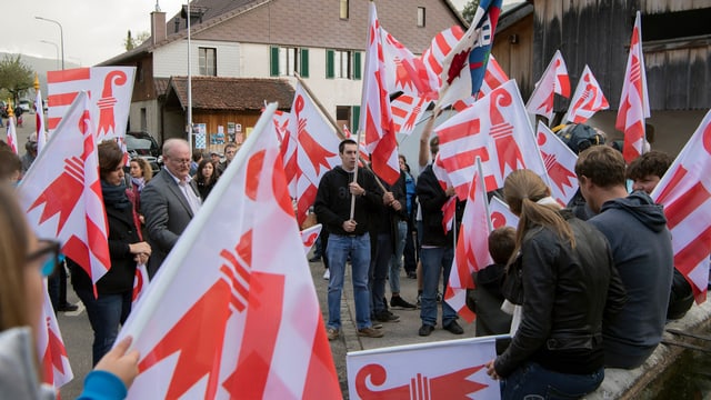 Menschen mit Jurafahnen stehen beeinander. Menschen mit Jurafahnen stehen beeinander.