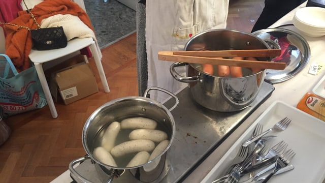 In zwei Kochtöpfen sieden Weiss- und Bockwürste. In zwei Kochtöpfen sieden Weiss- und Bockwürste.