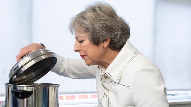 Theresa May schaut in einen Kochtopf. Theresa May schaut in einen Kochtopf.