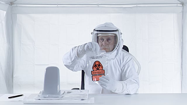 Ein Mann in einem weissen Anzug mit Helm und Visir. Ein Mann in einem weissen Anzug mit Helm und Visir.