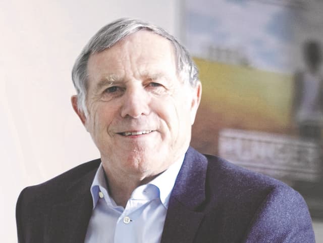 Ein Mann im hellblauen Hemd und dunklen Jackett vor einem Filmplakat. Ein Mann im hellblauen Hemd und dunklen Jackett vor einem Filmplakat.