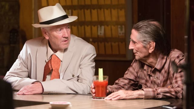 Filmszene: Zwei Männer sitzen an einer Bar und sprechen miteinander. Filmszene: Zwei Männer sitzen an einer Bar und sprechen miteinander.