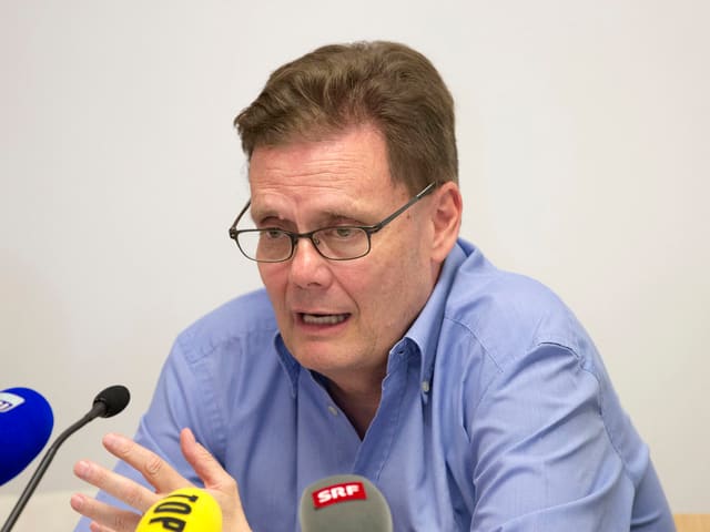 Urs Lauffer, in einem blauen Hemd vor Mikrofonen. Urs Lauffer, in einem blauen Hemd vor Mikrofonen.