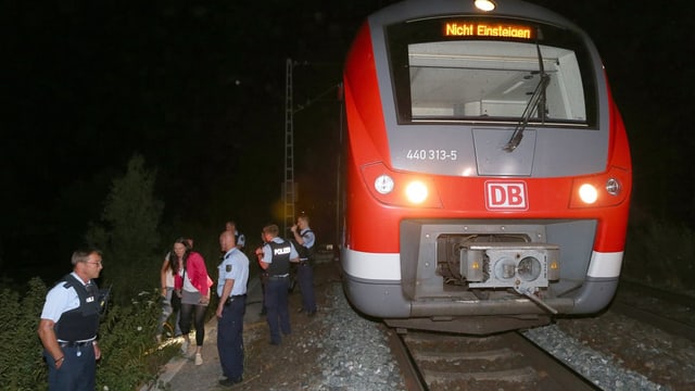 Angehaltener Zug. Polizisten davor. Angehaltener Zug. Polizisten davor.