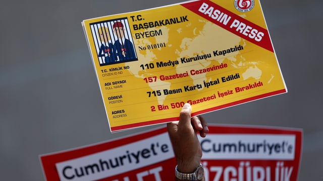 Hand hält ein Plakat, das wie ein Presseausweis aussieht. Hand hält ein Plakat, das wie ein Presseausweis aussieht.