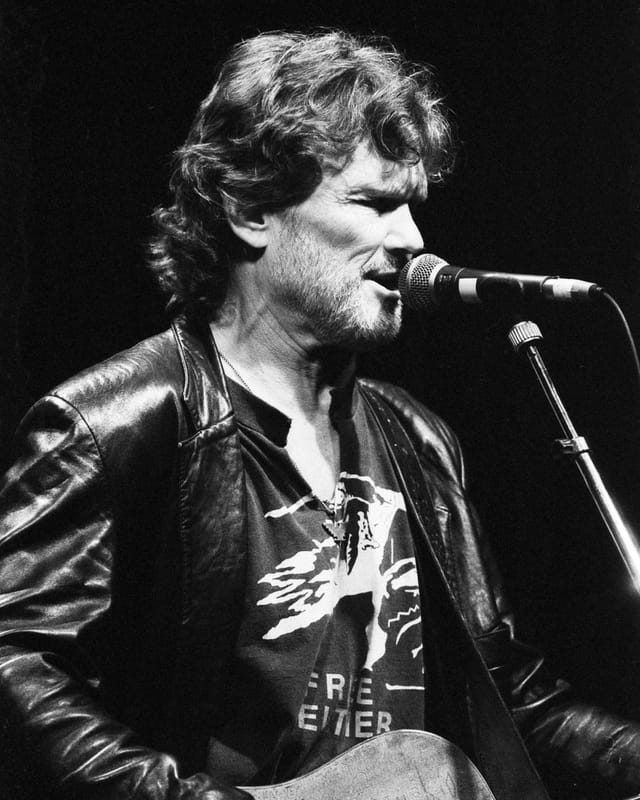 Schwarzweissfoto: Ein Mann in Lederjacke mit Gitarre. Schwarzweissfoto: Ein Mann in Lederjacke mit Gitarre.
