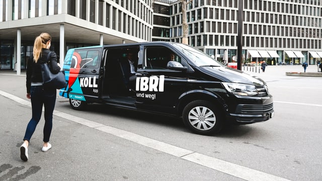 Frau läuft auf einen VW-Bus zu, dieser ist mit "Kollibri" beschriftet Frau läuft auf einen VW-Bus zu, dieser ist mit "Kollibri" beschriftet