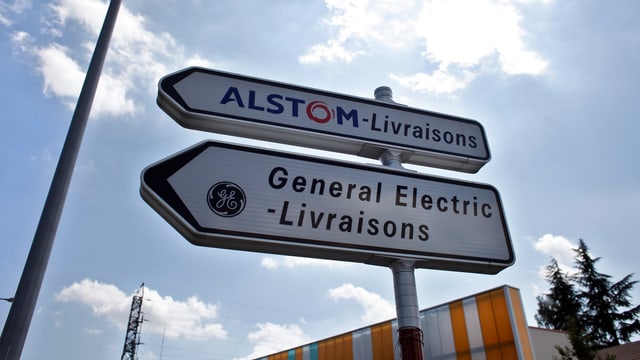 Wegweiser mit den Aufschriften General Electric und Alstom. Wegweiser mit den Aufschriften General Electric und Alstom.