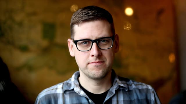 Jeff Lemire vor einer mit Kletterpflanzen bewachsenen Wand. Jeff Lemire vor einer mit Kletterpflanzen bewachsenen Wand.