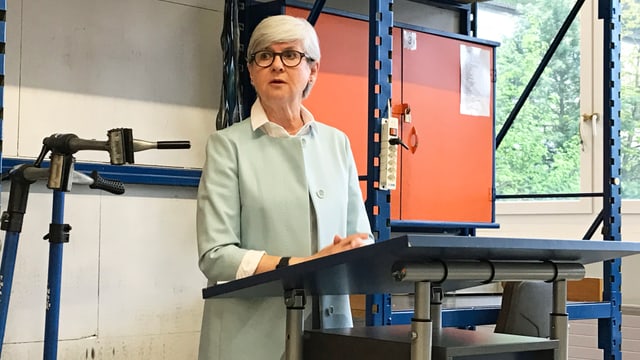 Eine Frau steht an einem Rednerpult. Eine Frau steht an einem Rednerpult.