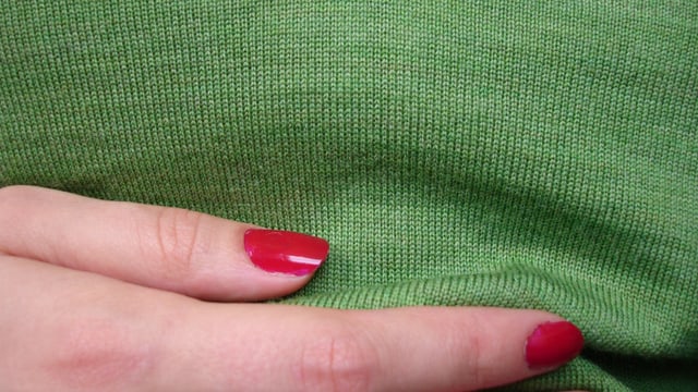 Eine Frau hält sich eine Hand an den Bauch. Eine Frau hält sich eine Hand an den Bauch.