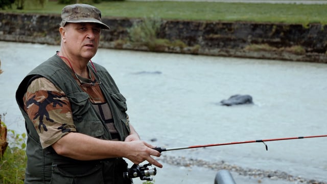 Ein Mann in Tarnkleidung beim Fischen. Ein Mann in Tarnkleidung beim Fischen.