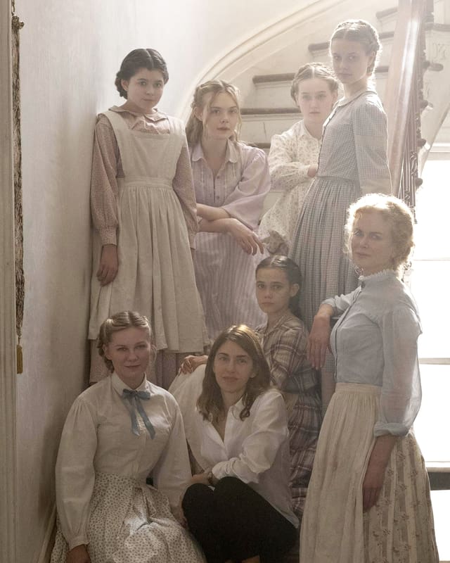 Die Regisseurin Coppola sitzt auf einer Treppe. Die Darstellerinnen umrahmen sie. Die Regisseurin Coppola sitzt auf einer Treppe. Die Darstellerinnen umrahmen sie.