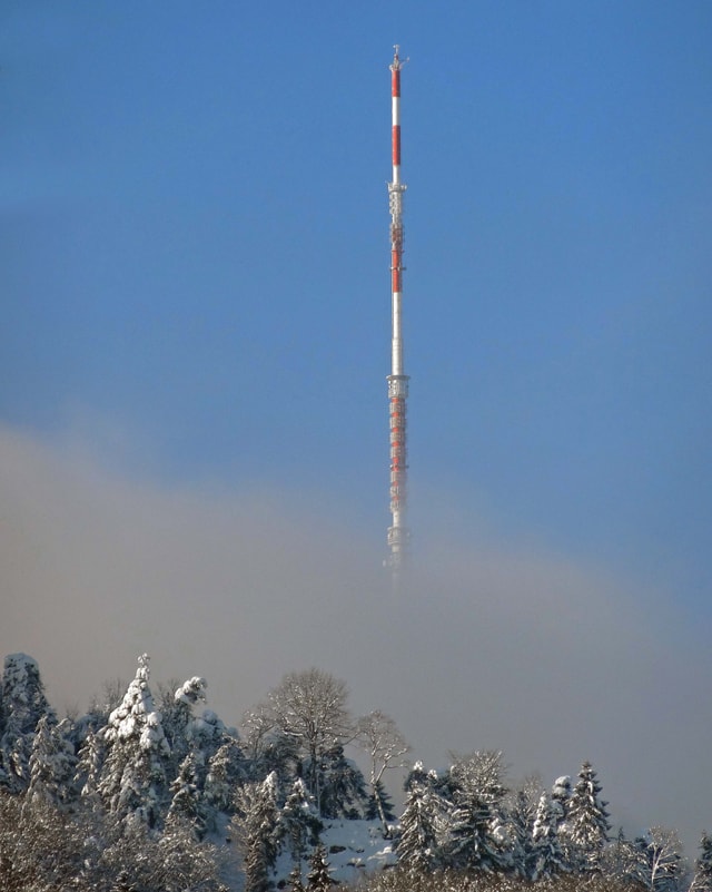 Der Sendeturm ragt aus dem Nebel.
