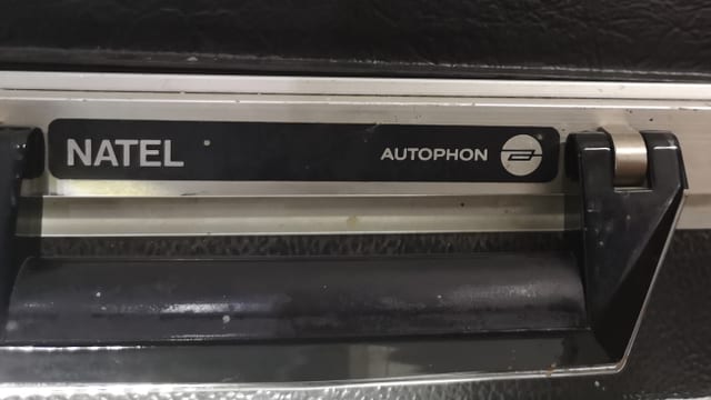 Schriftzüge Natel und Autophon neben Koffergriff. Schriftzüge Natel und Autophon neben Koffergriff.