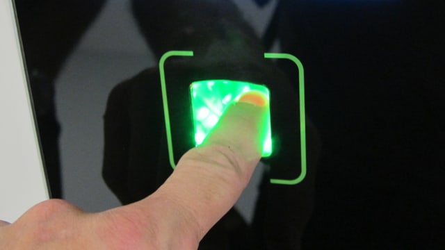 Ein Finger in einem Fingerabdruck-Scanner Ein Finger in einem Fingerabdruck-Scanner