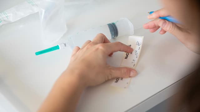 Eine Frau schreibt etwas auf einen Zettel. Eine Frau schreibt etwas auf einen Zettel.