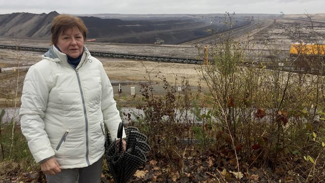 Eine Frau vor einer öden, zerfurchten Landschaft. Eine Frau vor einer öden, zerfurchten Landschaft.