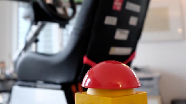 Ein grosser, roter Alarmknopf, der den Simulator bei Gefahr deaktiviert. Ein grosser, roter Alarmknopf, der den Simulator bei Gefahr deaktiviert.