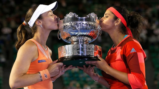 Martina Hingis und Sania Mirza küssen einen Pokal. Martina Hingis und Sania Mirza küssen einen Pokal.