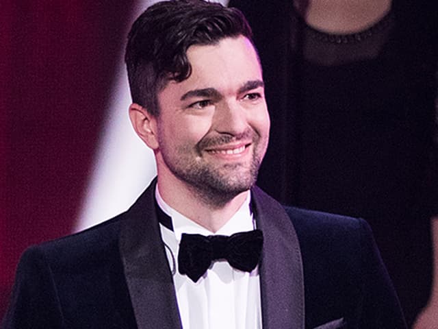 Samuel steht auf der ESC-Bühne und lächelt Samuel steht auf der ESC-Bühne und lächelt
