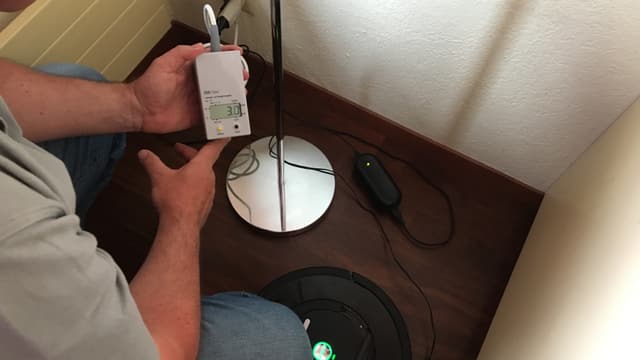 Ein Staubsaugerroboter im Standby wird gemessen Ein Staubsaugerroboter im Standby wird gemessen