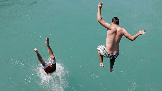 Zwei junge Männer springen in die Aare bei Bern Zwei junge Männer springen in die Aare bei Bern