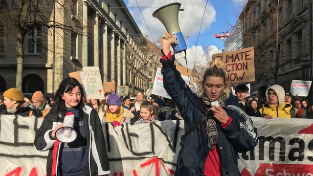 Eine Gruppe Schülerinnen läuft durch Zürich, vorneweg zwei junge Frauen mit einem Megafon in der Hand. Eine Gruppe Schülerinnen läuft durch Zürich, vorneweg zwei junge Frauen mit einem Megafon in der Hand.