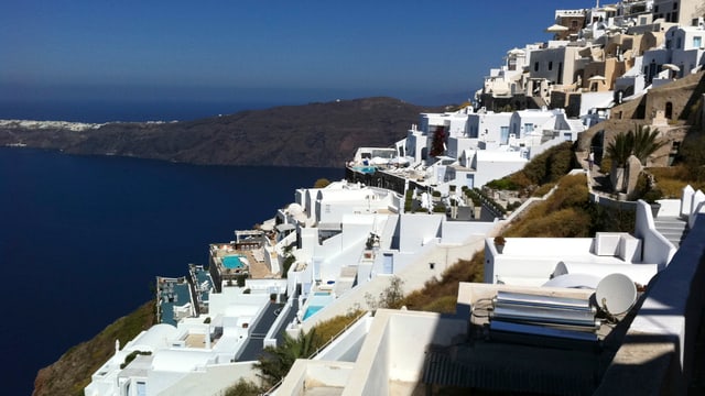Eine Ferienanlage auf der griechischen Insel Santorini an einem Abhang gelegen, links unten das tiefblaue Meer Eine Ferienanlage auf der griechischen Insel Santorini an einem Abhang gelegen, links unten das tiefblaue Meer