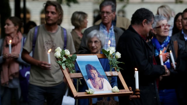 Foto von Adeline, im Hintergrund Menschen mit Kerzen Foto von Adeline, im Hintergrund Menschen mit Kerzen