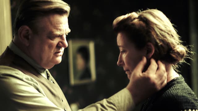 Ein Mann streicht seiner Frau über das Gesicht, beide schauen bedrückt. Ein Mann streicht seiner Frau über das Gesicht, beide schauen bedrückt.